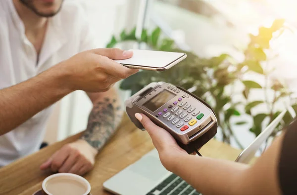 Hombre pagando factura a través de teléfono inteligente utilizando la tecnología NFC — Foto de Stock