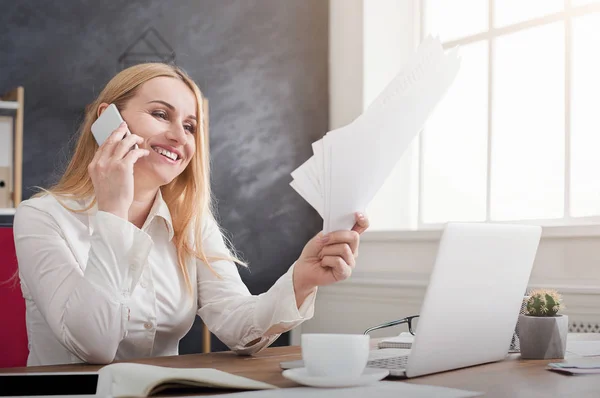 Elegante junge Geschäftsfrau hält Dokumente in der Hand und telefoniert — Stockfoto