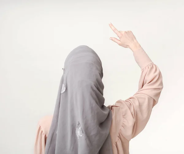 Muslimin zeigt auf virtuellen Bildschirm, kopiert Raum — Stockfoto
