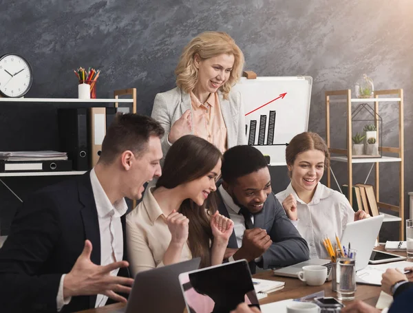 Счастливая, жизнерадостная деловая команда смотрит на ноутбук — стоковое фото