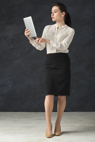 Geballte Frau mit Tablet auf grauem Hintergrund — Stockfoto