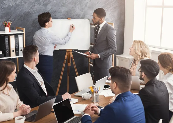 Woman and man giving presentation to colleagues in office — Stock Photo, Image