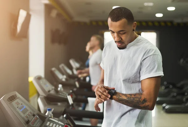 Jovem usando rastreador de fitness no ginásio — Fotografia de Stock