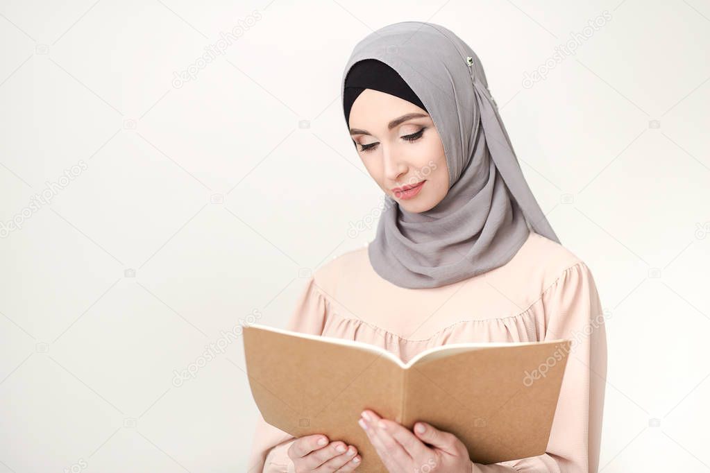 Islamic woman in hijab reading book