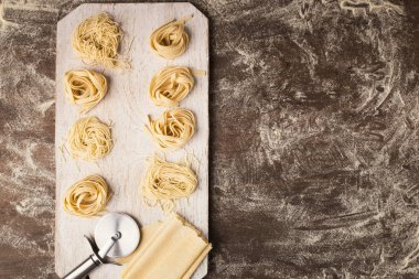 Ham tagliatelle yuva ve hamur kesme tahtası üzerinde