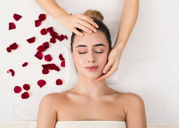 Mujer recibiendo masaje facial profesional en salón de belleza —  Fotos de Stock