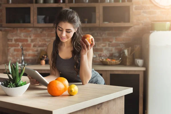 Feliz joven comiendo frutas en la cocina —  Fotos de Stock