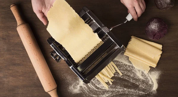 Preparing homemade fettuccine on pasta machine — Stock Photo, Image