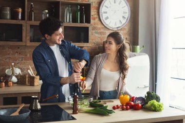 Mutlu çift birlikte yemek pişiriyor.