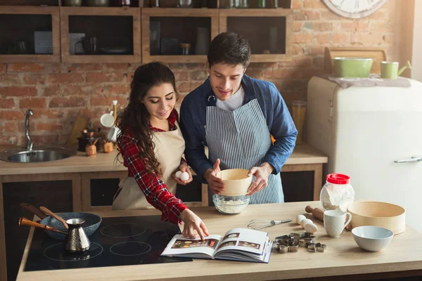 Feliz joven mujer y hombre horneando en la cocina loft —  Fotos de Stock