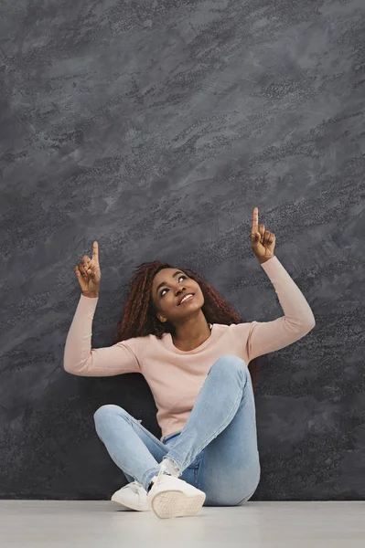 Chica Africana Feliz Sentado Suelo Señalando Los Dedos Hacia Arriba — Foto de Stock