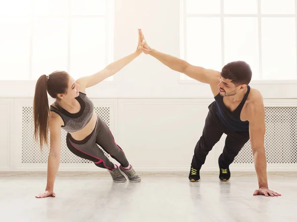 Sporty casal dando alta cinco enquanto fazendo push-up — Fotografia de Stock