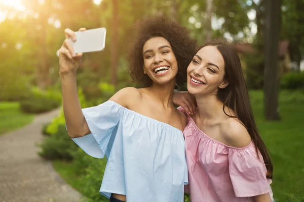 Dos mujeres jóvenes lindas tomando selfie en el parque —  Fotos de Stock
