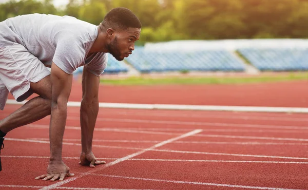 African-american male sportsman ready to run on stadium track — Stock Photo, Image