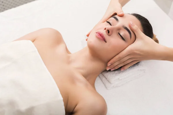 Frau bekommt professionelle Gesichtsmassage im Wellnesssalon — Stockfoto