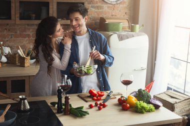 Mutlu çift birlikte yemek pişiriyor.