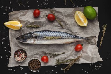 Taze balık ve siyah masada yemek malzemeler