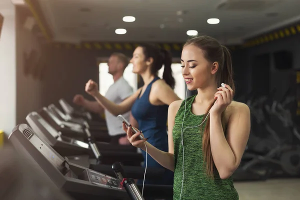 Mulher atraente na esteira no clube de fitness — Fotografia de Stock