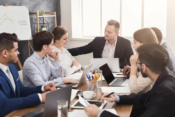 Equipo joven discutiendo proyecto en oficina moderna — Foto de Stock