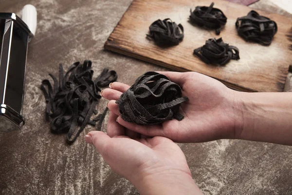 Woman making tagliatelle nest on kitchen table — Stock Photo, Image