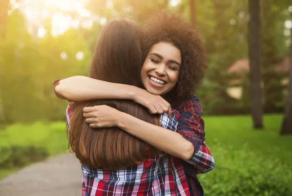 Two happy young girls hug each other outdoors — Stock Photo, Image