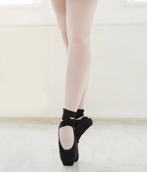 Балерина в пуантах, изящные ноги, балетный фон — стоковое фото