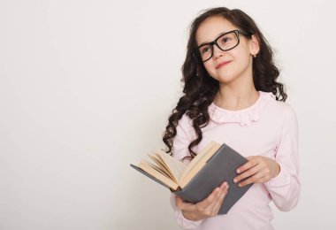 Küçük kız kitap okuyor.