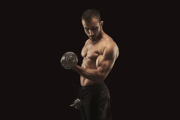 Strong man with dumbbell showing muscular body — Stock Photo, Image