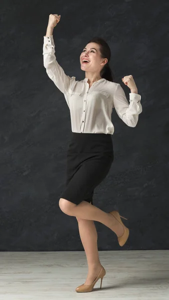 Mujer emocionada celebrando el éxito, bailando en el fondo del estudio —  Fotos de Stock