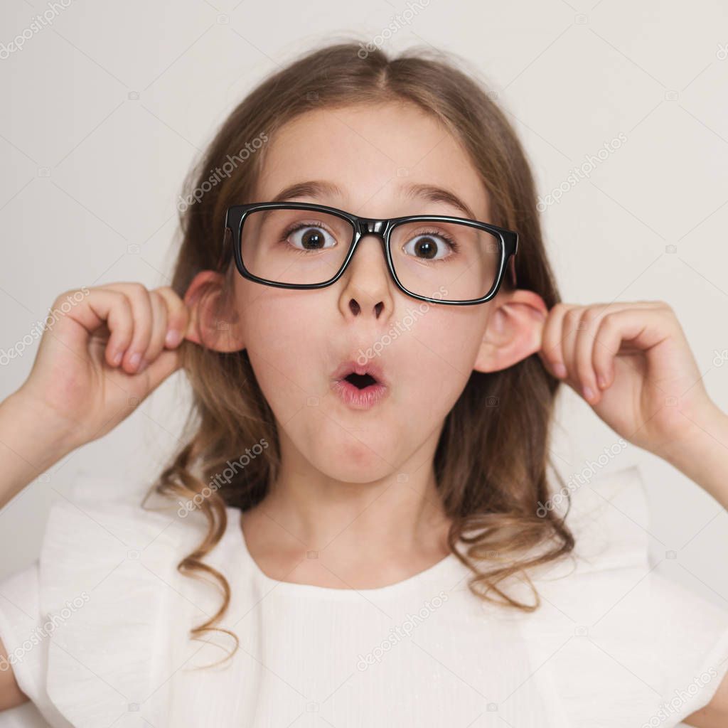 Little girl grimacing with tongue out making ears protruding