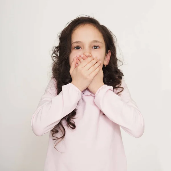 Choqué petite fille couvrant sa bouche par les mains — Photo