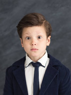 Little boy in business suit with shocked expression clipart