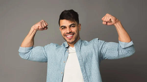 Hombre fuerte mostrando bíceps en el fondo del estudio — Foto de Stock