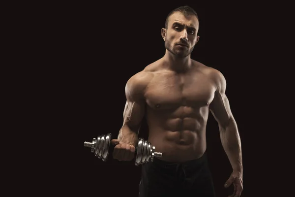 Hombre fuerte con mancuerna mostrando cuerpo muscular — Foto de Stock