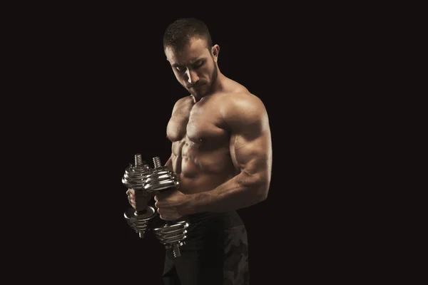 Hombre fuerte con mancuerna mostrando cuerpo muscular — Foto de Stock