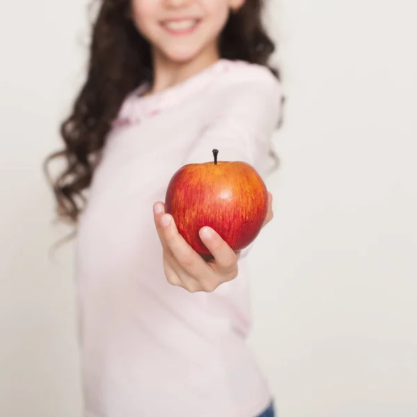 赤いリンゴを提供している笑顔の少女 — ストック写真