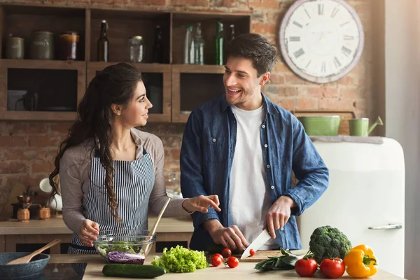 Pareja feliz cocinando juntos una cena saludable — Foto de Stock