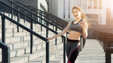 Tamam gösterilen genç atletik kız stadyum üzerinde oturum