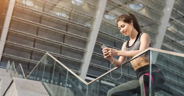 Sportliche Frau hört Musik — Stockfoto