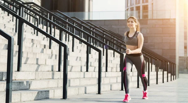 Mujer delgada corriendo en las escaleras del estadio — Foto de Stock