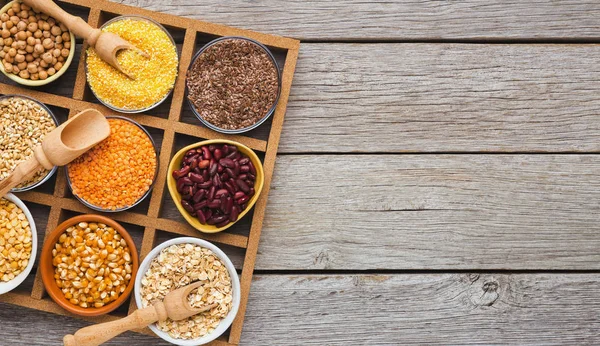 Surtido de cereales y legumbres en mesa de madera — Foto de Stock