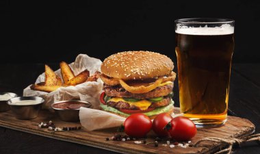Sığır eti ve bira ahşap kesme tahtası üzerinde yapılan hamburger