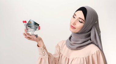 Satın alma kavramı. Arap kadın küçük arabası ve kredi kartı ile
