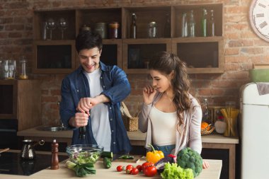 Mutlu çift birlikte yemek pişiriyor.