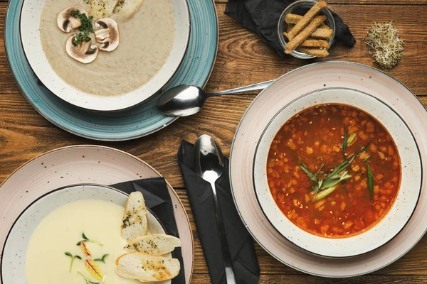 Drei verschiedene Suppen auf Holztisch — Stockfoto