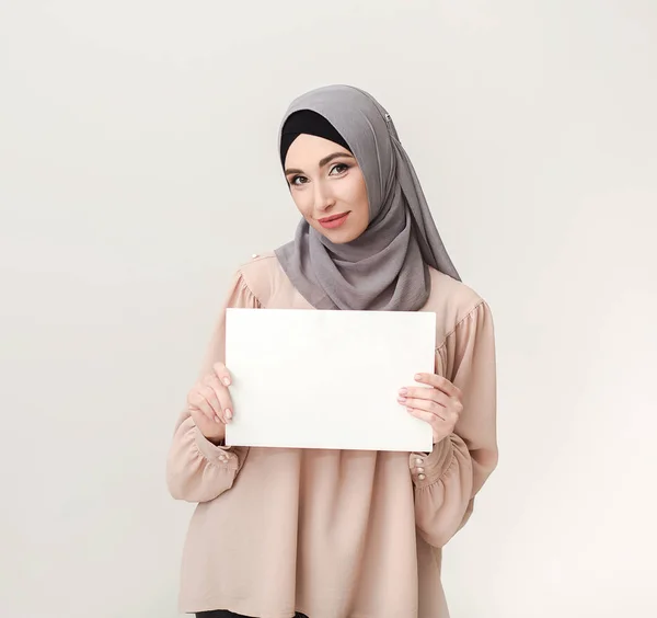 Mujer islámica con tablero en blanco sobre blanco —  Fotos de Stock