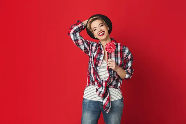 Happy casual fille avec sucette rayée à fond rouge — Photo