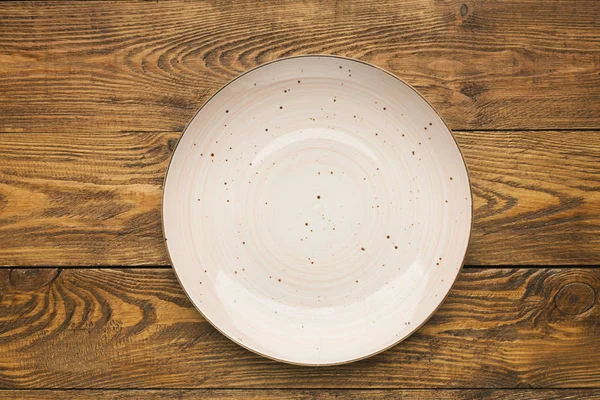 Woden asztal üres rózsaszín kerámia tányér — Stock Fotó