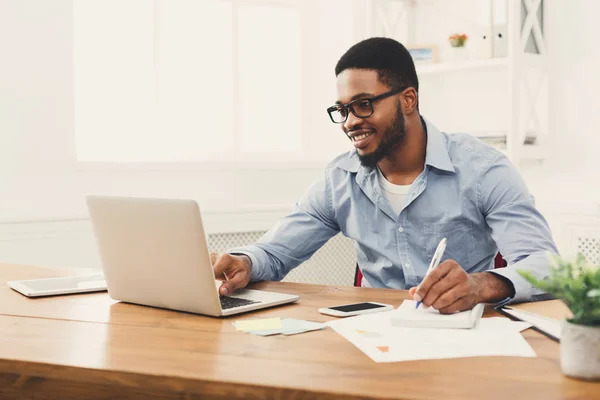 Young black businessman working with laptop