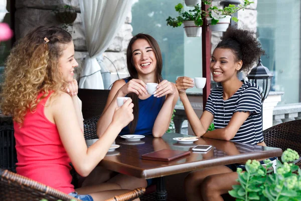 Meninas felizes sentadas no café e conversando — Fotografia de Stock